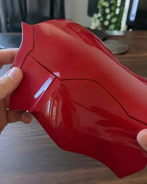 A glossy red printed armor plate held in both hands