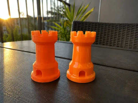 Two orange printed rooks: raw layer lines on the left, mirror finish on the right