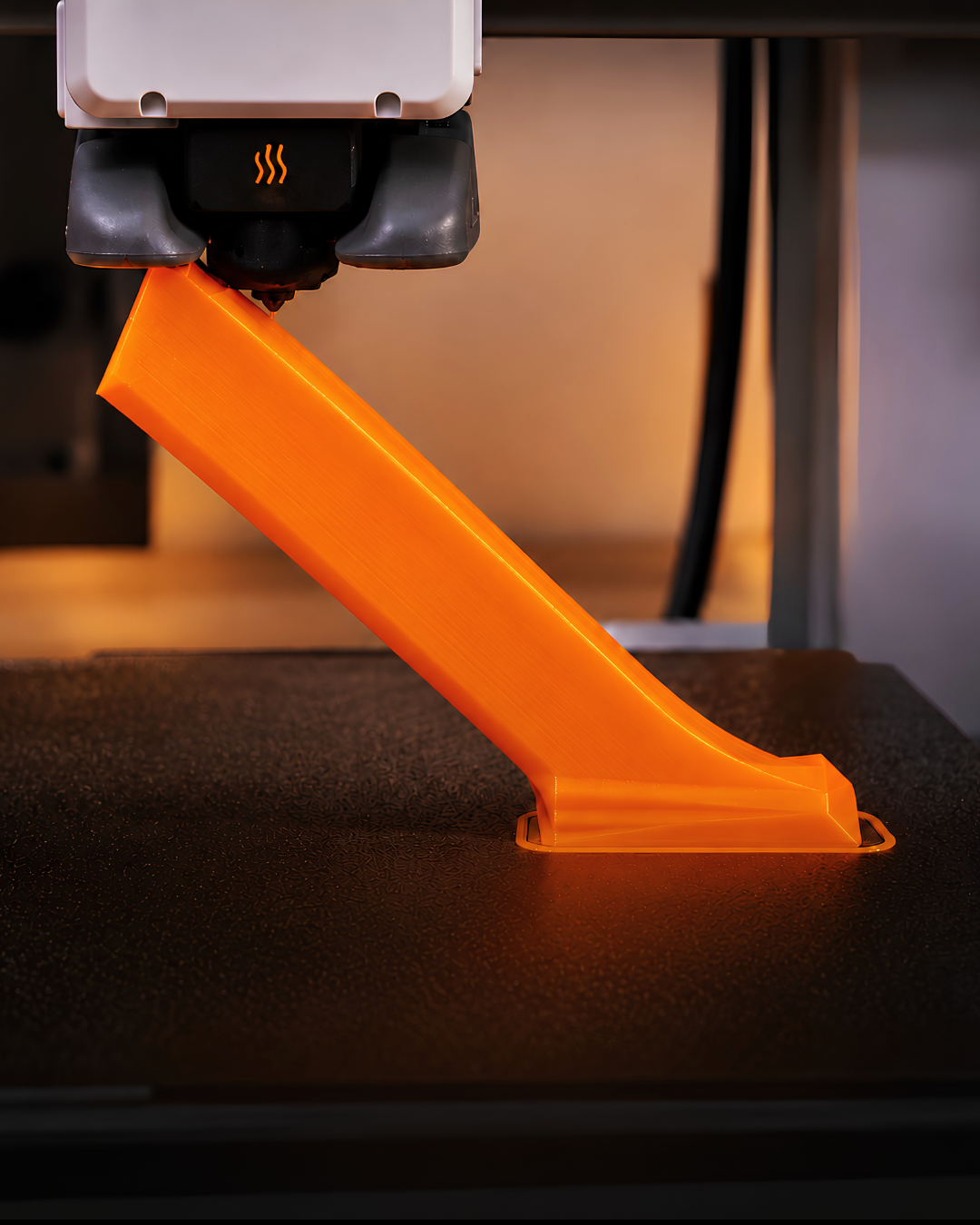 Un outil de finition imprimable orange en cours d’impression sur une imprimante 3D